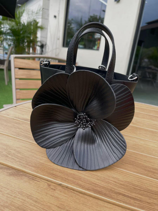 Elegant black flower-adorned handbag showcasing a versatile piece for stylish occasions