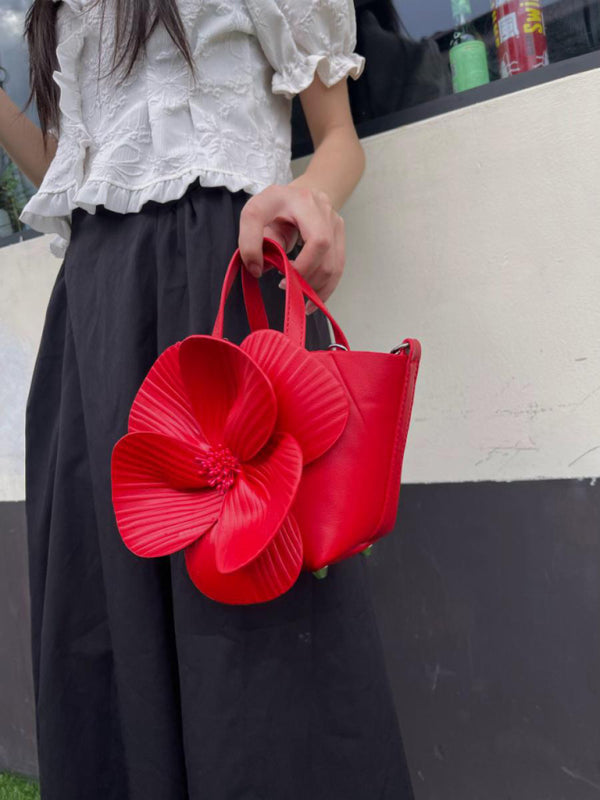 Red leather handbag with large flower detail, a versatile piece for stylish occasions
