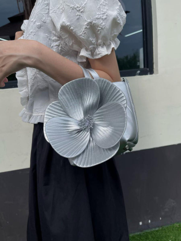 Silver flower-shaped handbag showcasing a versatile piece for stylish crossbody wear