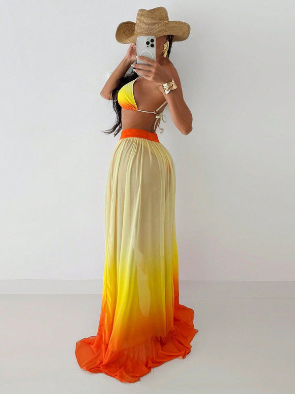 Woman in a yellow and orange ombre skirt with bikini top and straw hat at Sunset Red Bikini event