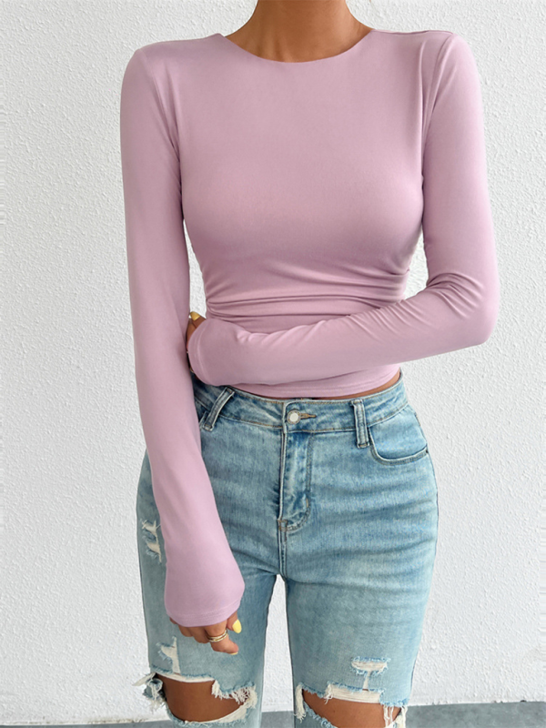 Woman wearing a pink long-sleeved top and ripped jeans showcasing the Slim Fit Open Back Knit Top