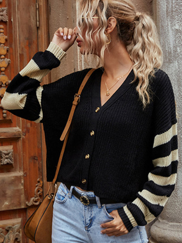 Woman wearing a black and beige striped sweater coat with dropped shoulder sleeves