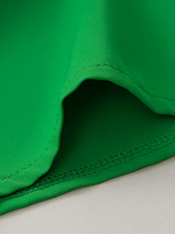Close-up of green fabric detail on a feminine solid color sleeveless shirt top
