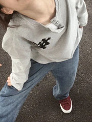 GRAY HOODIE AND JEANS OUTFIT WITH BOLD CROSS PRINT