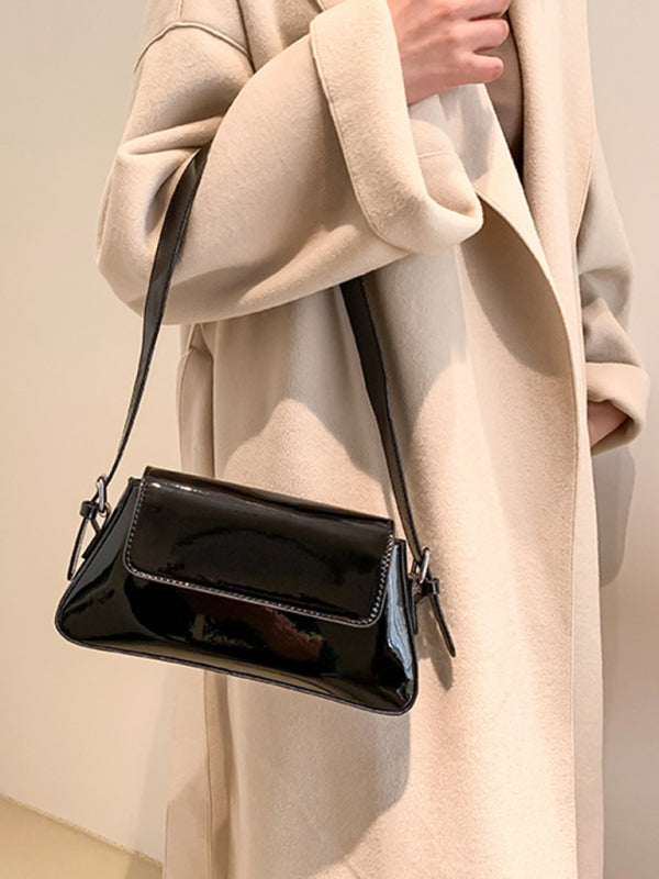 Modische Damen-Schultertasche aus Lackleder mit Baguette-Struktur und glänzendem Finish, die unter dem Arm getragen wird 