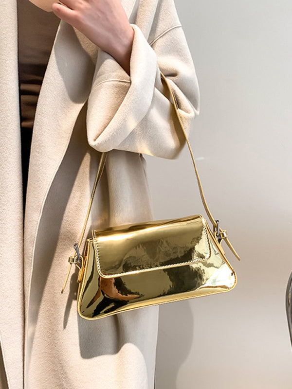 Modische Damen-Schultertasche aus Lackleder mit Baguette-Struktur und glänzendem Finish, die unter dem Arm getragen wird 