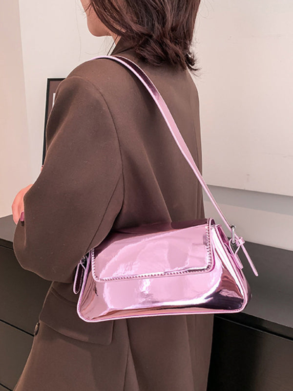 Modische Damen-Schultertasche aus Lackleder mit Baguette-Struktur und glänzendem Finish, die unter dem Arm getragen wird 