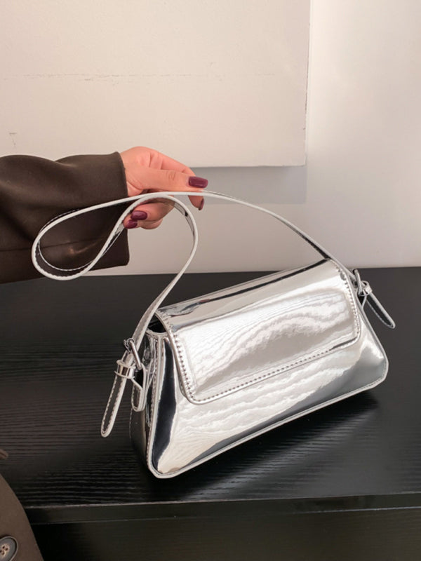 Modische Damen-Schultertasche aus Lackleder mit Baguette-Struktur und glänzendem Finish, die unter dem Arm getragen wird 