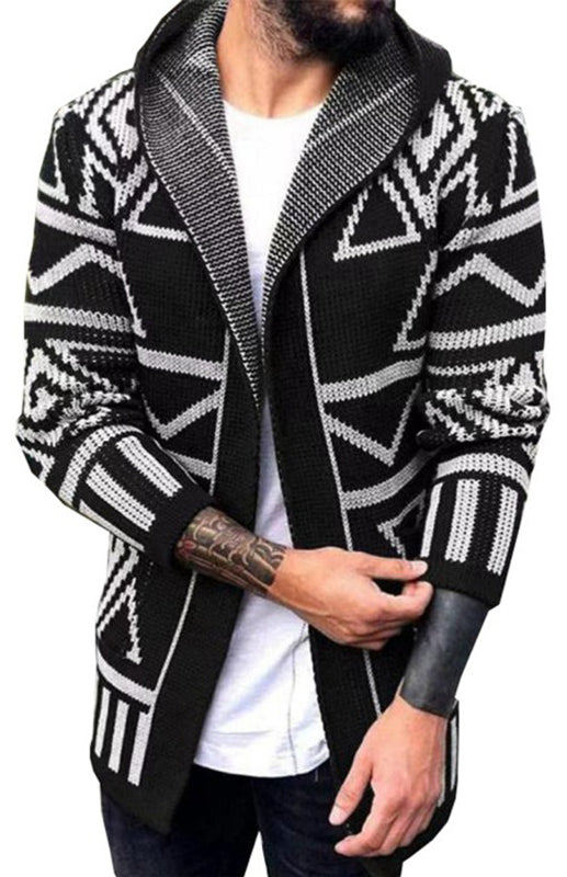 Man wearing a black and white long jacquard knitwear cardigan sweater with a lapel collar and dropped shoulder sleeves over a white t-shirt.