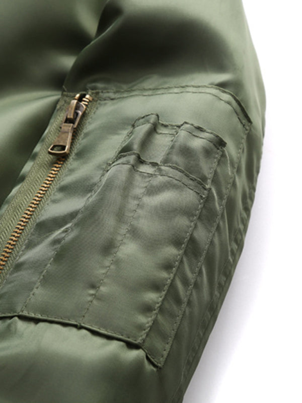 Close-up of green nylon jacket sleeve showing flap pocket and zipper detail.