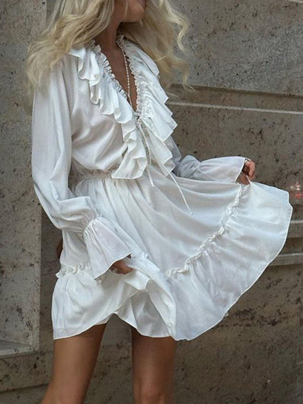 Robe blanche à décolleté plongeant en V, manches trompette smockées et taille à volants 