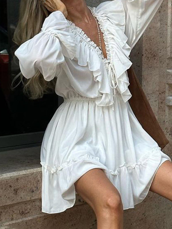 Robe blanche à décolleté plongeant en V, manches trompette smockées et taille à volants 