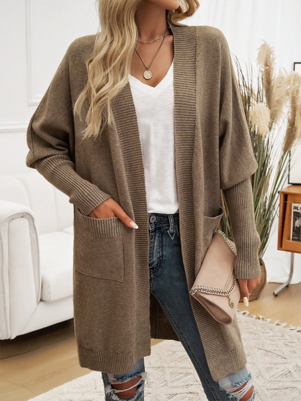 Woman wearing a Batwing Sleeve Cardigan Solid Color Sweater Jacket paired with a white V-neck shirt, distressed jeans, and a beige purse.