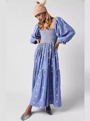 Robe bleue à manches trompette décontractées, col carré brodé et motif tournesol, style moderne. 