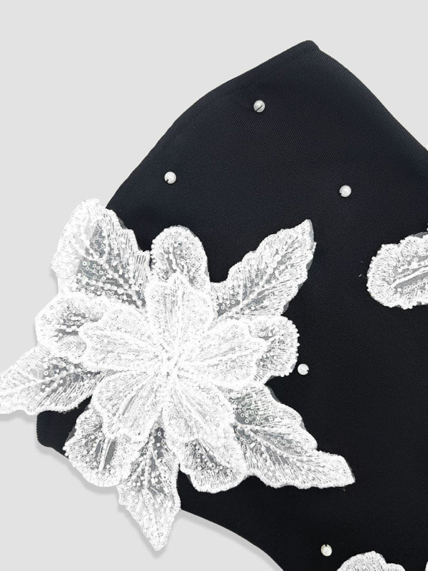 Robe bustier noire courte en maille, ornée de perles et de fleurs, idéale pour les fêtes de fin d'année. 