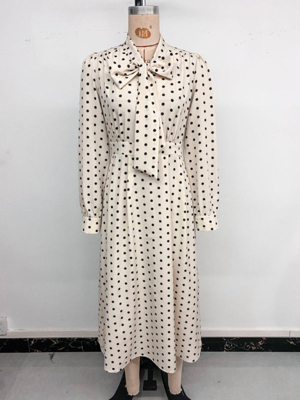 Robe élégante mi-longue à pois, col à nœud papillon, manches longues et taille marquée. 