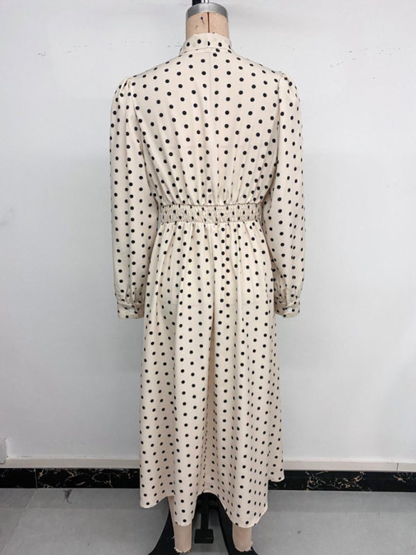 Robe élégante mi-longue à pois, col à nœud papillon, manches longues et taille marquée. 