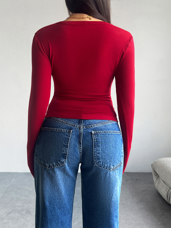Red long-sleeved top and blue jeans worn with a solid color cardigan T-shirt