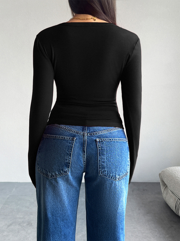 Woman wearing a solid color black long-sleeved top and blue jeans for the cardigan product