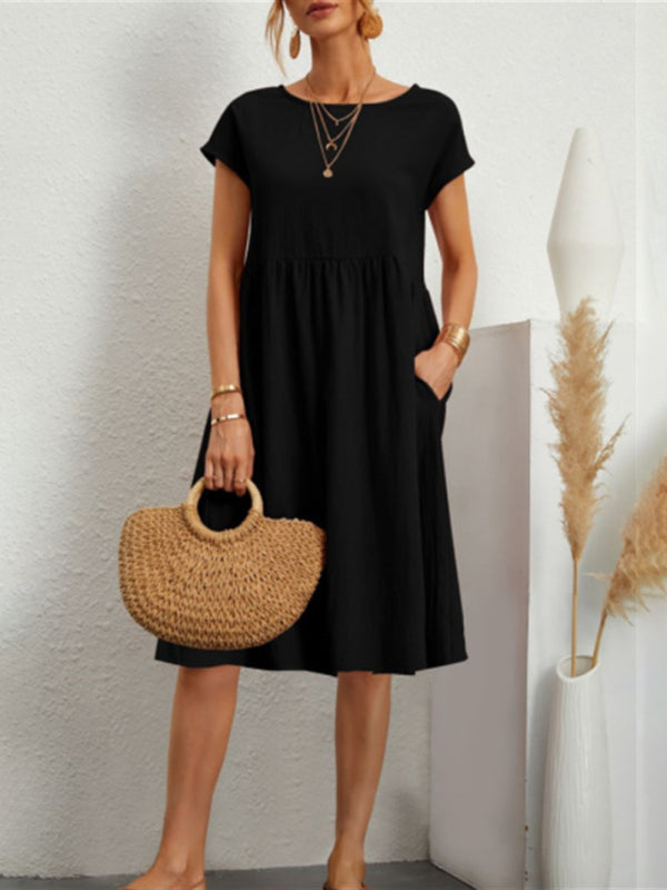 Black midi dress with round neck and cotton sleeve, paired with straw bag